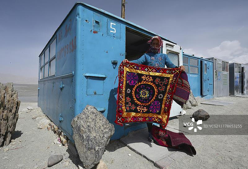 中国新疆帕米尔丝绸之路：哈萨克族妇女展示手织刺绣壁毯图片素材