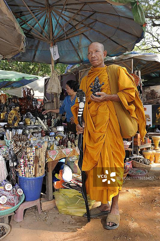 佛教僧侣在柬埔寨吴哥窟的纪念品商店购买圣徒雕像图片素材