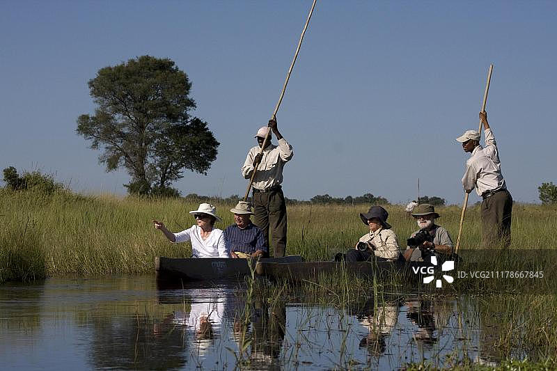 游客在博茨瓦纳奥卡万戈三角洲乘坐独木舟图片素材