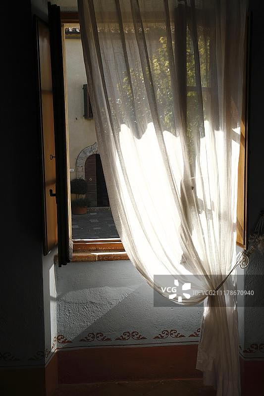 透过透明的白色窗帘观赏意大利托斯卡纳的广场图片素材