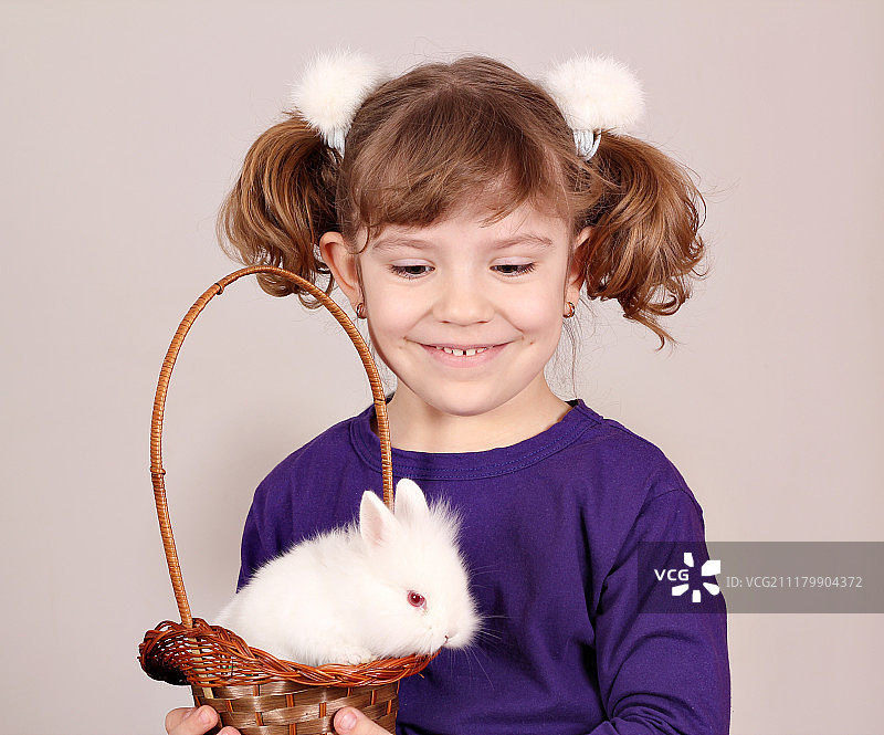 快乐的小女孩抱着白色兔子图片素材