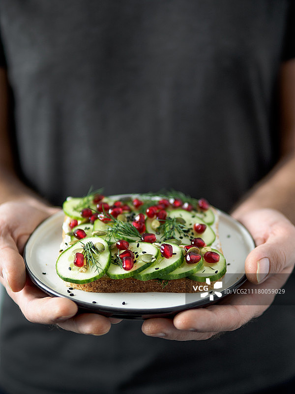 男性手中的黄瓜纯素三明治图片素材