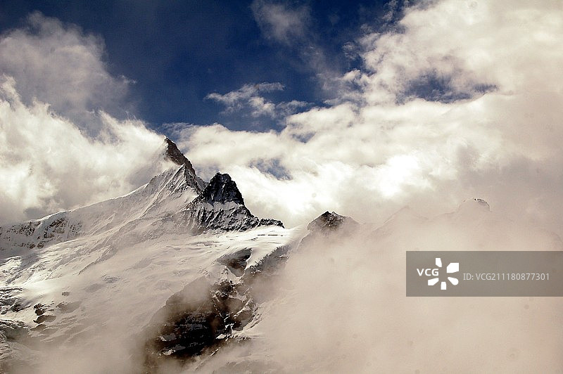 被浓密云层覆盖的雪山山脉图片素材