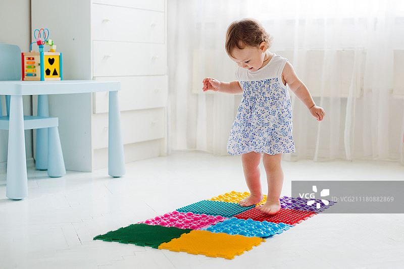 女婴在足底按摩垫上行走图片素材