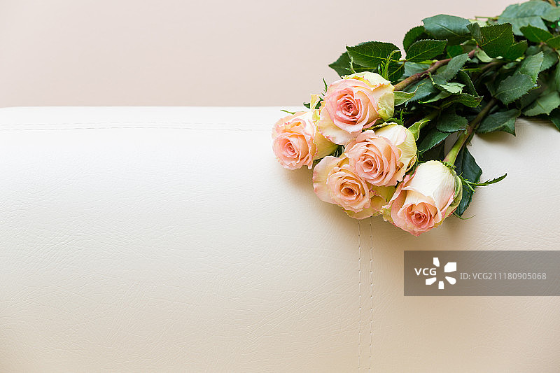 白色沙发上的一束茶香玫瑰图片素材