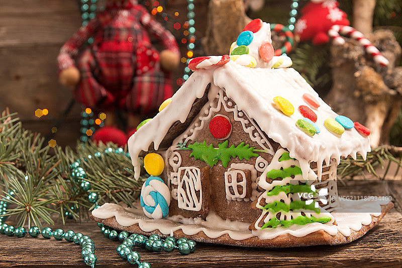 圣诞节姜饼屋和旧木板上的节日装饰品图片素材