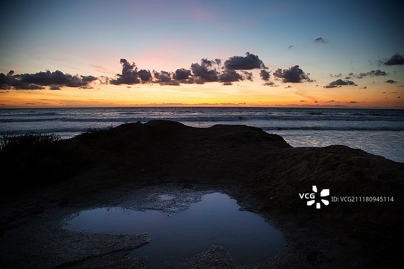 托里松树海滩的潮汐池反映日落天空图片素材