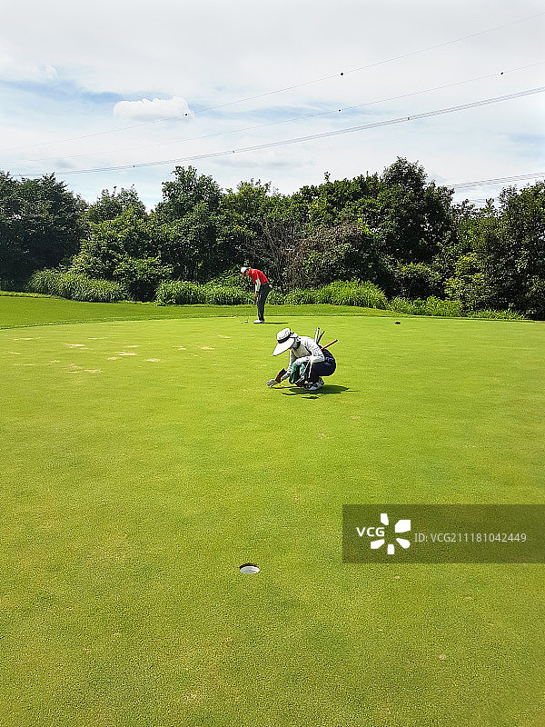 高尔夫、高尔夫球场、果岭、高尔夫球手、球童、球洞杯图片素材