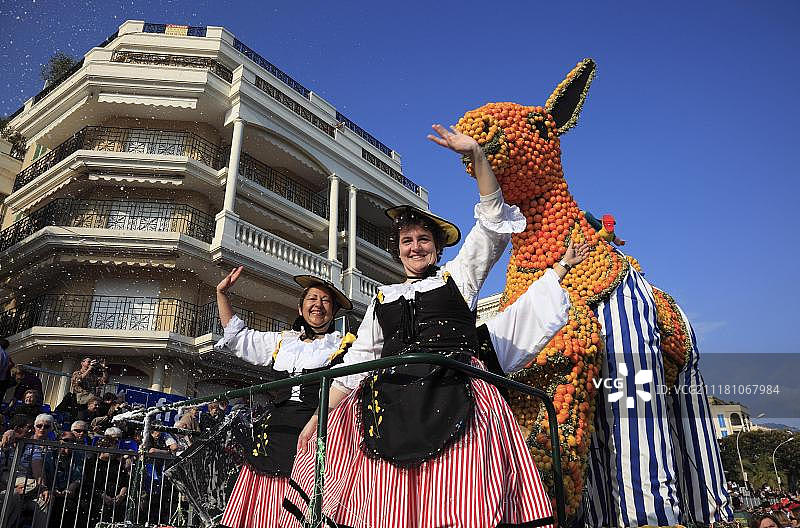 女性在柑橘水果花车前挥手，柠檬节，芒通，法国，欧洲图片素材