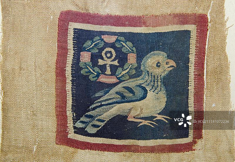 纺织板：描绘一只鸟，带有花环十字，呈法老安卡形式，是公元5-7世纪来自埃及上阿赫米姆的生命象征图片素材