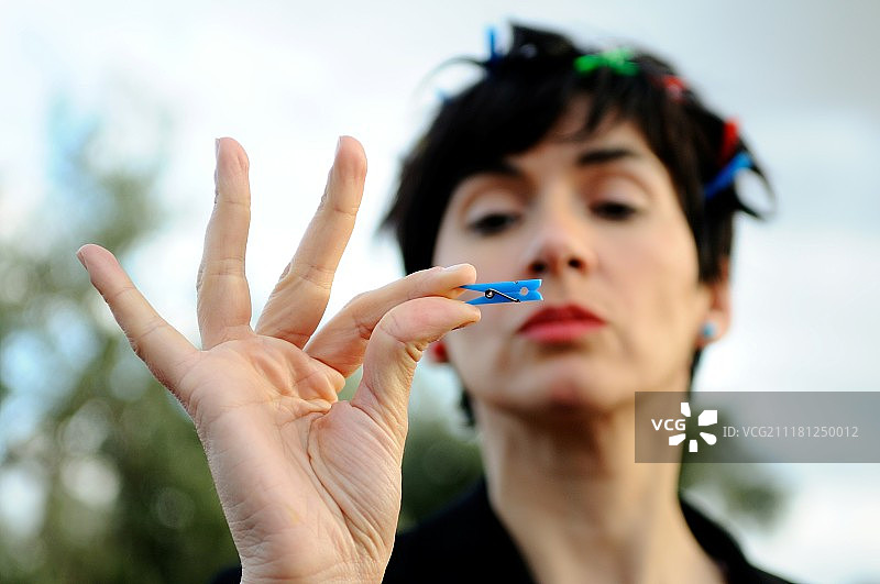 女人拿着蓝色小木钉图片素材