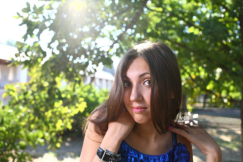 在公园里穿着蓝色连衣裙的性感年轻女性肖像图片素材