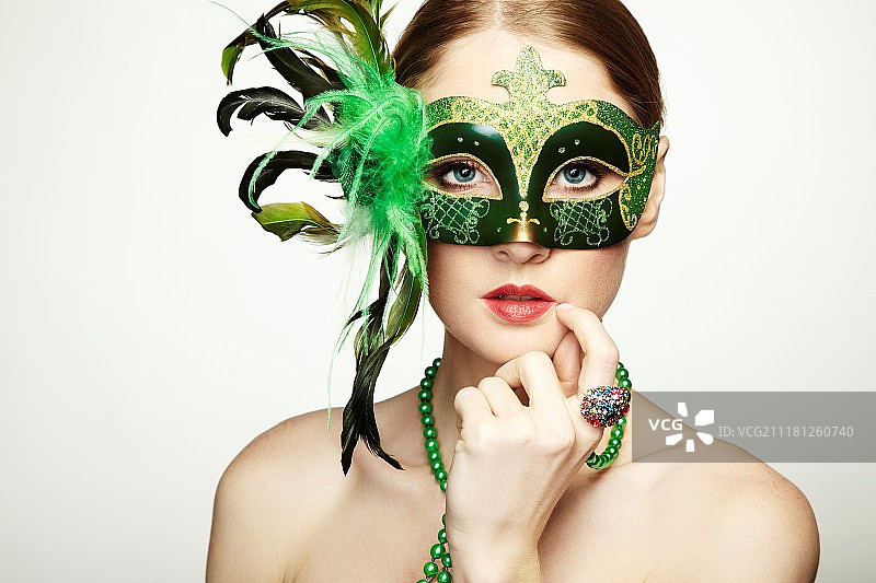戴着绿色威尼斯面具的美丽年轻女子图片素材