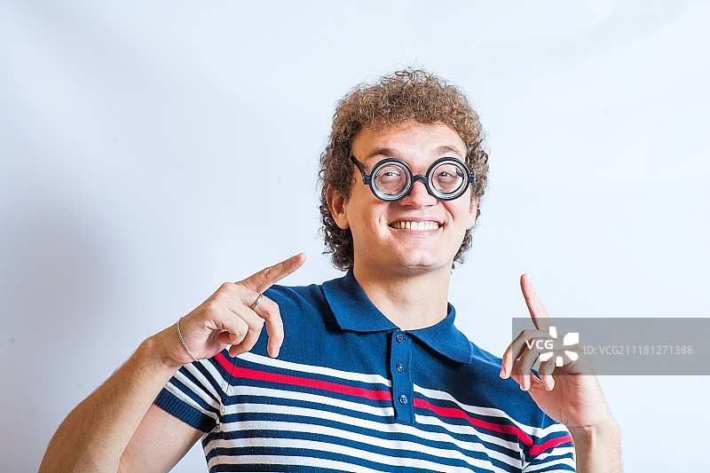 戴着书呆子眼镜，在工作室中玩乐的男人肖像图片素材