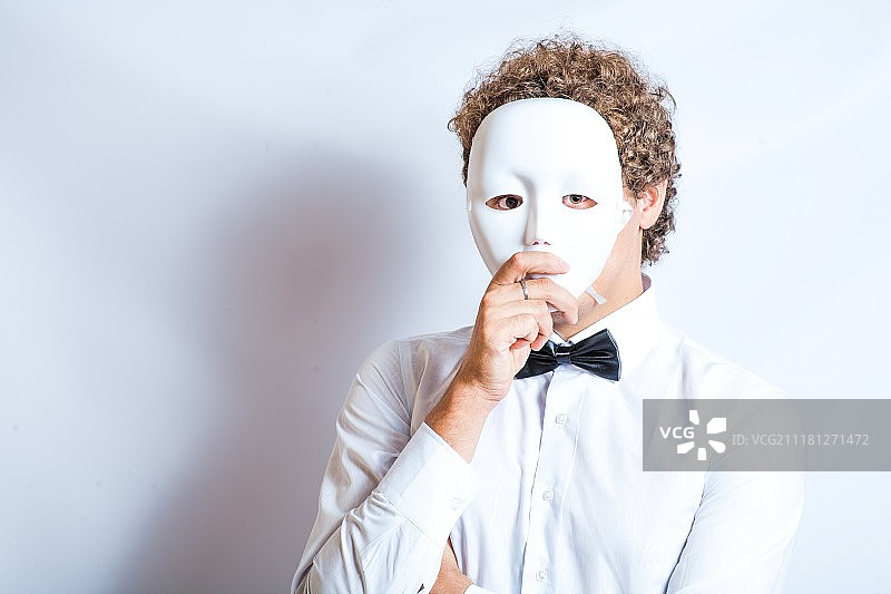 默剧演员面部特写，思考中的表情，黑色领结和面具图片素材