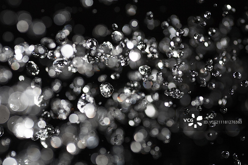 空中飞舞的水滴（背景虚化灯光）图片素材