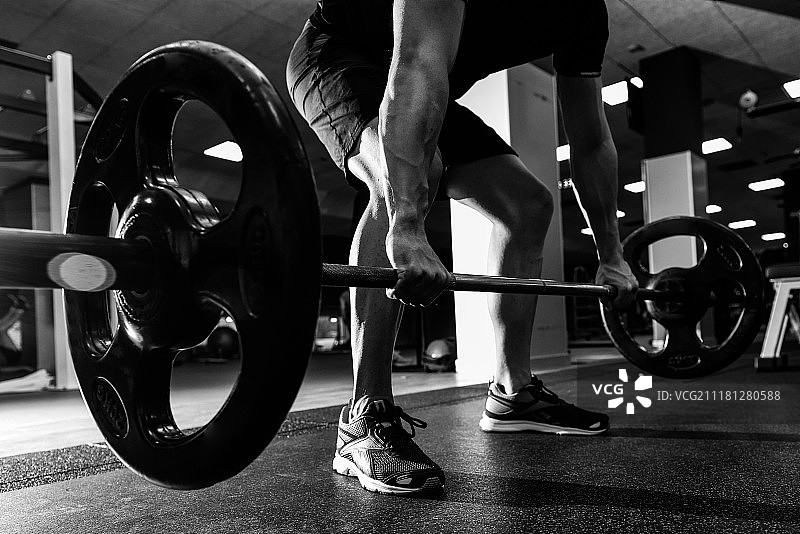 健身房杠铃举重训练特写：男子身穿运动服图片素材