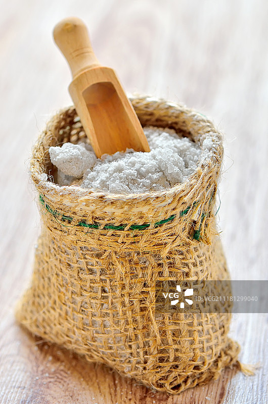 木制背景上的黄麻袋装海盐图片素材