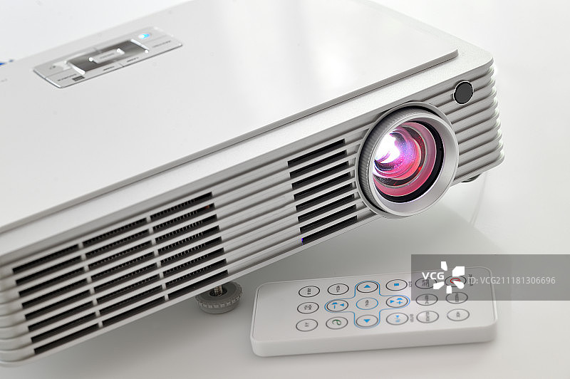 白色桌子上的便携式LED投影仪图片素材