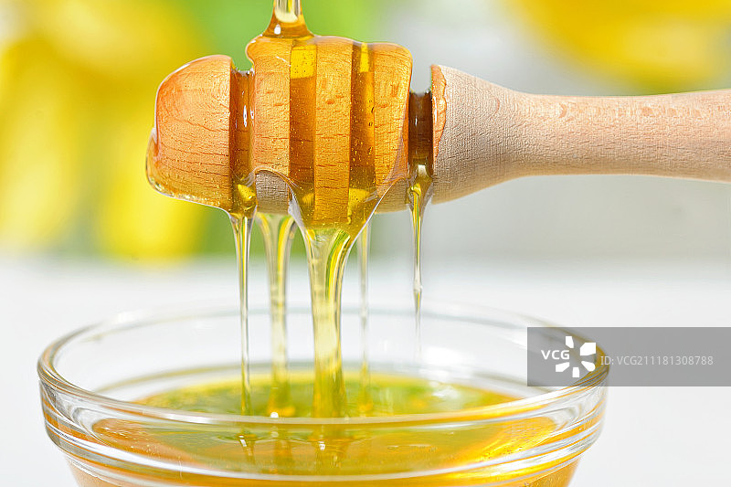蜂蜜从蜂蜜棒上滴落图片素材