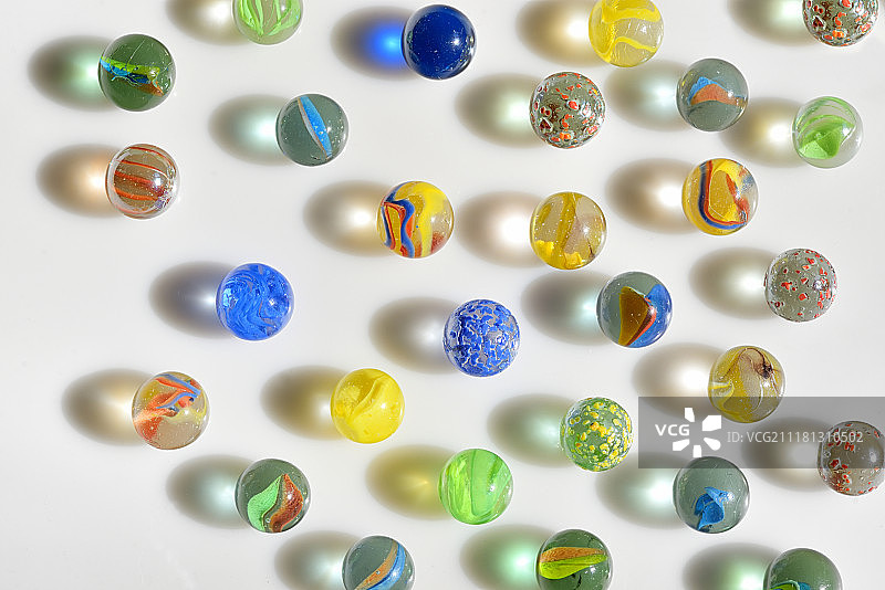 白色桌子上的彩色玻璃弹珠图片素材