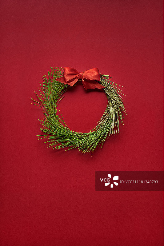 红色背景上的树枝圣诞花环创意概念照片图片素材