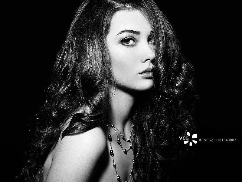 留着长卷发的美丽女人。发型优雅的漂亮女孩。时尚照片。黑白的图片素材