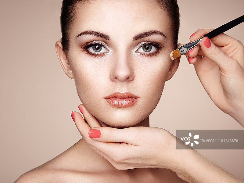 化妆师涂抹肤色，美丽的女人面部，完美妆容，护肤粉底图片素材