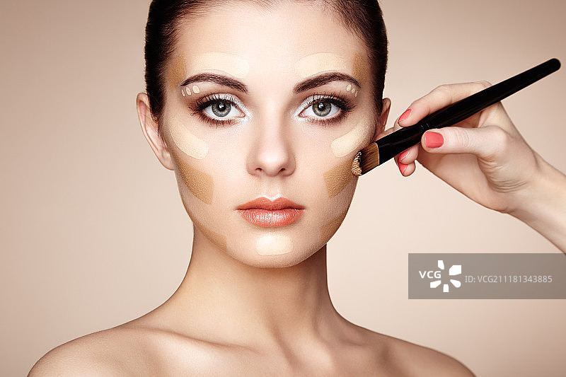 化妆师涂抹肤色，美丽的女人面部，完美妆容，护肤粉底图片素材