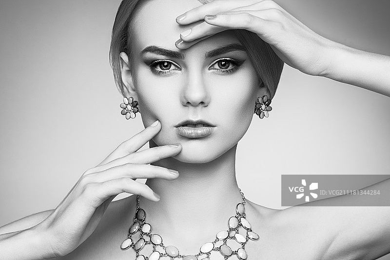 拥有优雅发型，妆容精致的美丽性感女人肖像。金发女孩。时尚照片。珠宝。黑白的图片素材