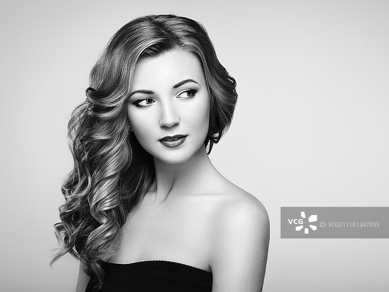 拥有浓密光泽波浪长发的金发女人，发型完美的漂亮模特，美妆模特图片素材