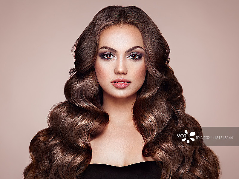棕发卷发女子，健康亮丽的卷发，护理和美丽图片素材