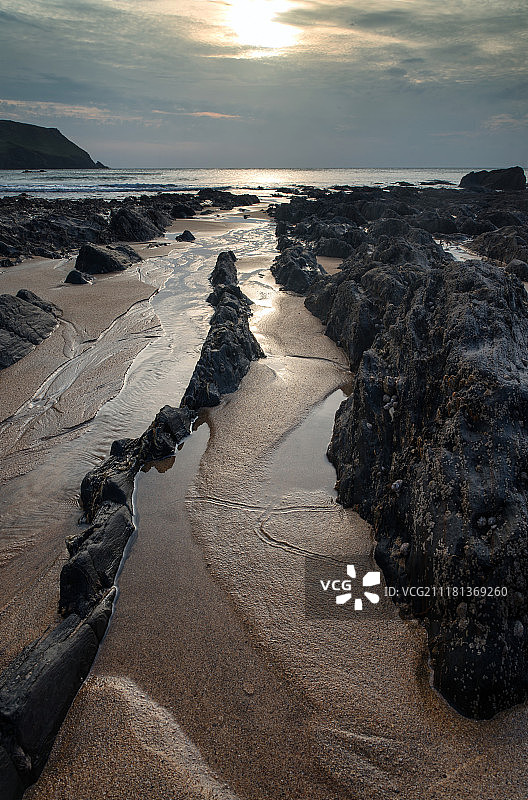 英格兰霍普湾岩石海岸线的日落海景图片素材
