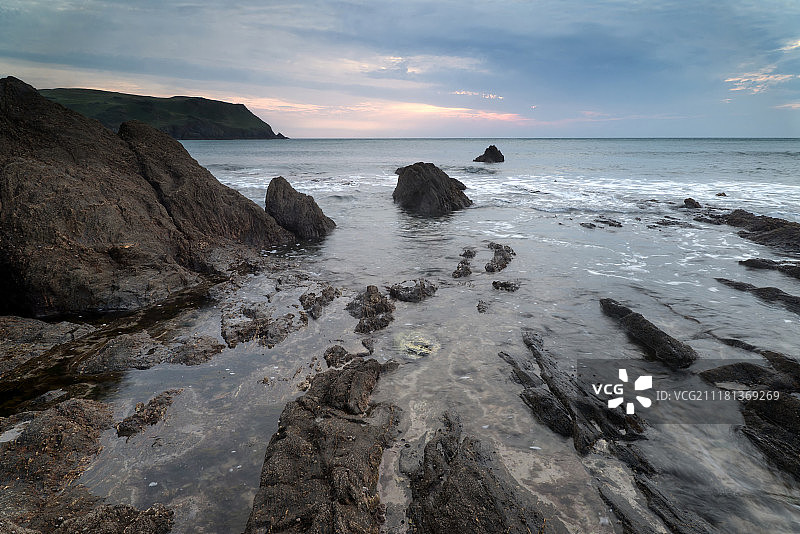 英格兰霍普湾岩石海岸线的日落海景图片素材