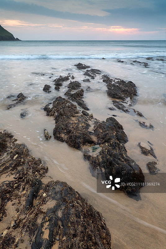 英格兰霍普湾岩石海岸线的日落海景图片素材