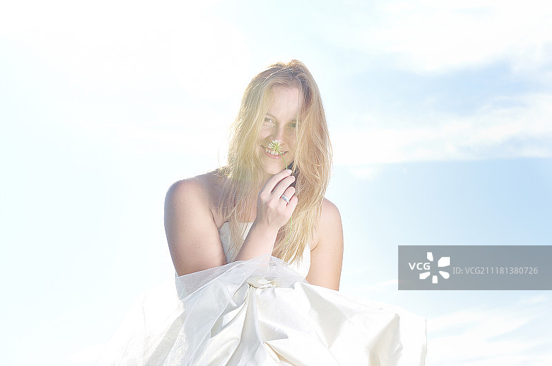 婚礼仪式后在日落时分的草地上玩耍的快乐年轻美丽新娘图片素材