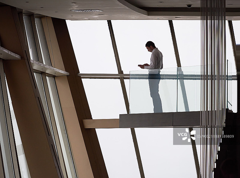 在复式公寓办公室使用平板电脑的年轻有为的商人图片素材