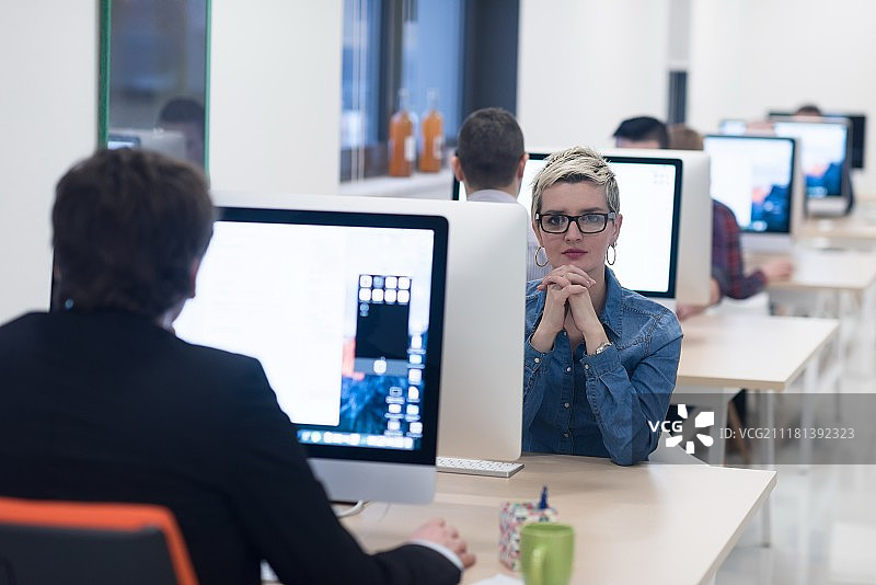 创业公司，在创意现代办公室放松娱乐的女人使用台式电脑工作图片素材