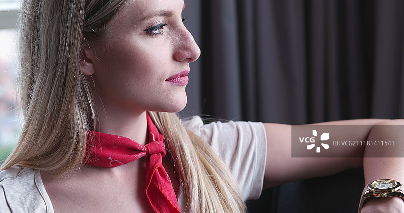 坐在沙发上使用平板电脑的金发女人图片素材