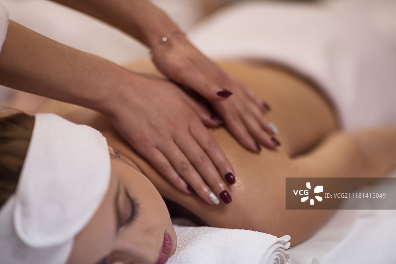 年轻女人俯卧接受背部按摩特写照片图片素材
