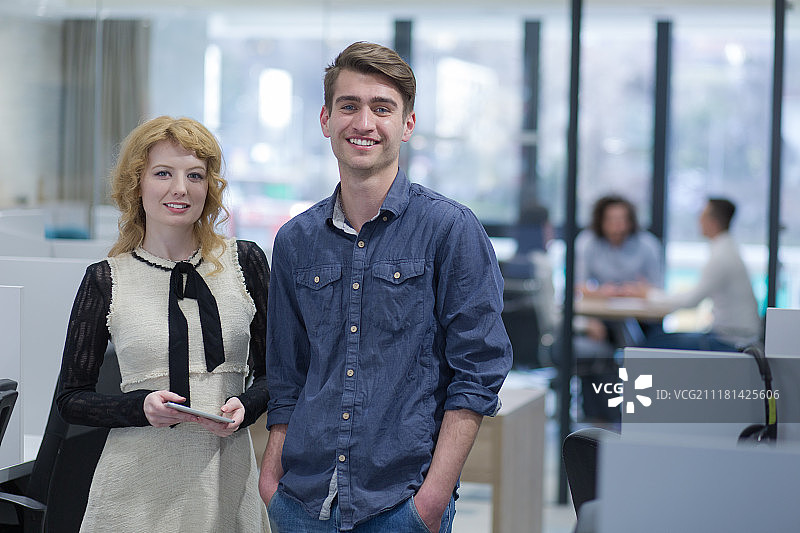 商务人士使用平板电脑为下次会议做准备，同事在创业办公室讨论想法图片素材