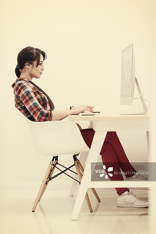 创业公司，在创意现代办公室放松娱乐的女人使用台式电脑工作图片素材