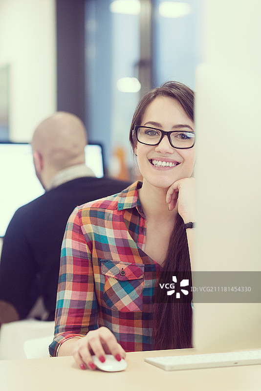 创业公司，在创意现代办公室放松娱乐的女人使用台式电脑工作图片素材