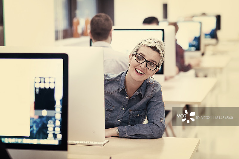 创业公司，在创意现代办公室放松娱乐的女人使用台式电脑工作图片素材