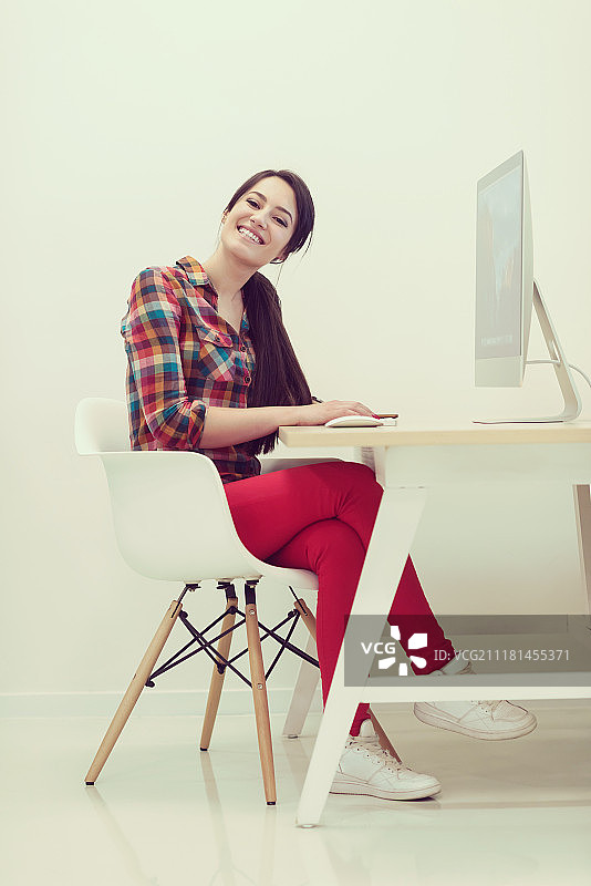 创业公司，在创意现代办公室放松娱乐的女人使用台式电脑工作图片素材