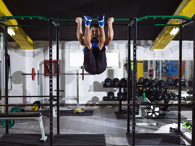 健壮的男人在单杠上做引体向上图片素材