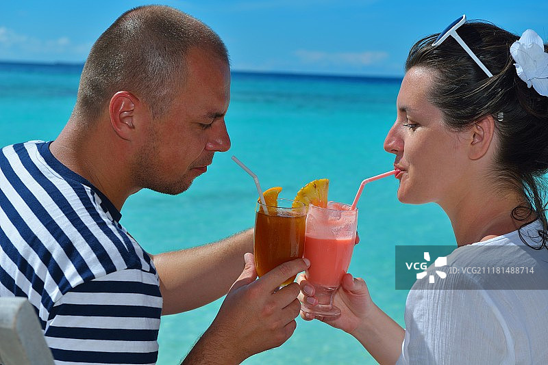 幸福的年轻情侣在夏季假期放松身心，享用清凉饮品图片素材