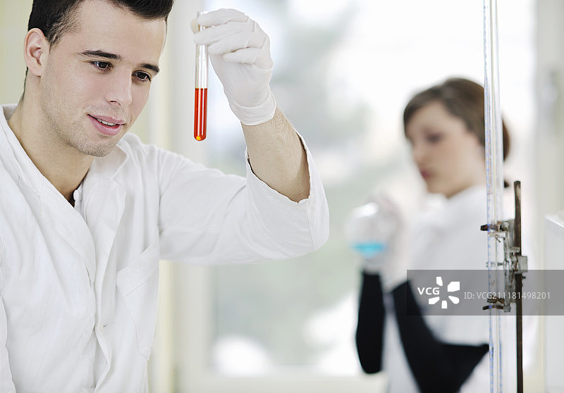 在明亮实验室里做实验的年轻学生情侣图片素材