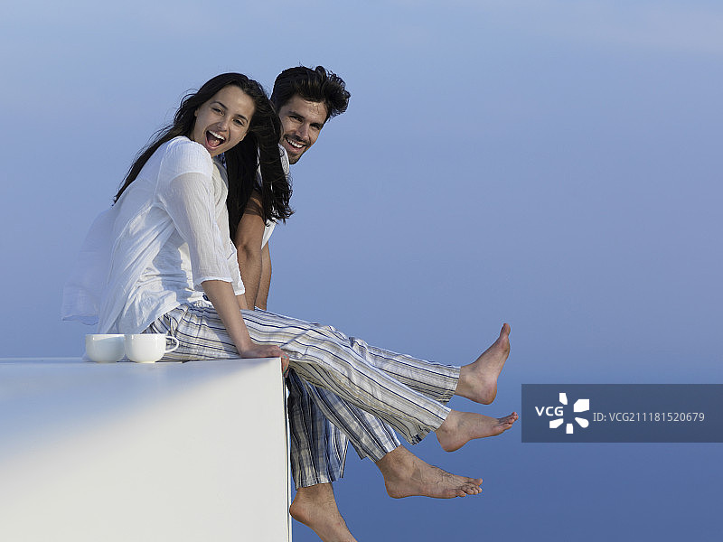 快乐的年轻浪漫的情侣，有乐趣，放松的微笑，在现代的家户外露台阳台露台图片素材