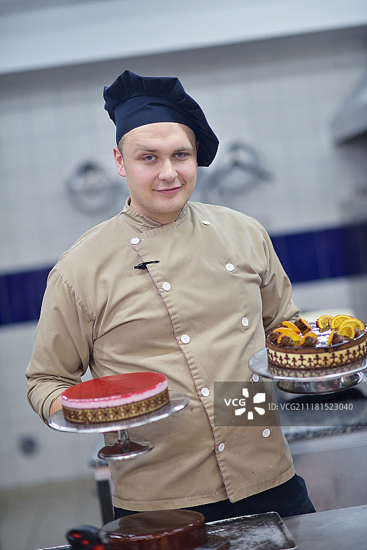 专注的男糕点师在厨房装饰甜点蛋糕 close-up图片素材